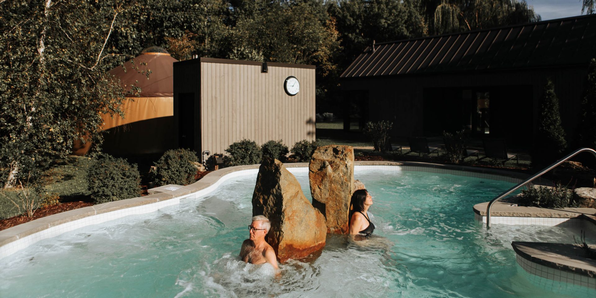 Un homme et une femme relaxent dans un bain extérieur du Strøm spa nordique Mont-Saint-Hilaire